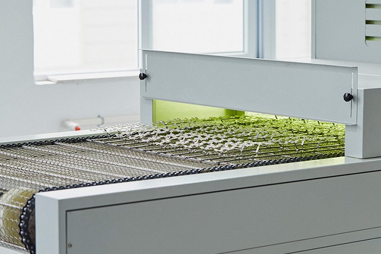 Close-up of the automated UV LED curing tunnel ensuring fast and even drying for bulk wholesale press-on nails.