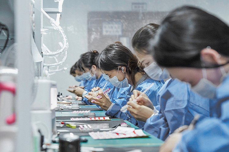 Skilled production team manually painting custom press-on nails at Lavara factory facility.